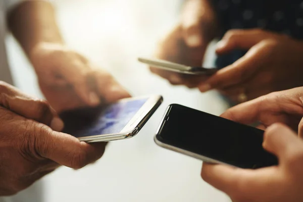 Liga-te e fica a saber. Foto de perto de um grupo de empresários irreconhecíveis usando seus celulares em sincronia. — Fotografia de Stock