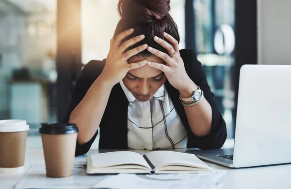 Tem férias quando precisas de uma. Tiro de uma jovem empresária olhando estressada enquanto trabalhava em sua mesa em um escritório moderno. — Fotografia de Stock