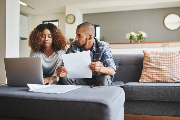 Temos de rever estas finanças. Tiro cortado de um jovem casal estressado sentado juntos e usando um laptop para rever sua papelada financeira. — Fotografia de Stock