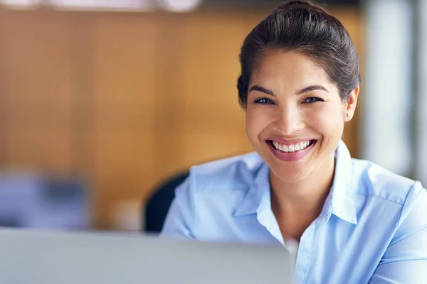 Ela orgulha-se do seu trabalho. Retrato recortado de uma jovem empresária trabalhando em seu laptop no escritório. — Fotografia de Stock