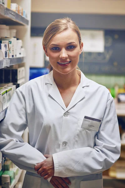 Tiene una actitud compasiva y servicial. Fotografía de una joven atractiva que trabaja en una farmacia. — Foto de Stock