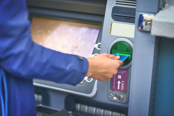Картка, готівка. Обрізаний знімок жінки, що робить операцію зі своєю банківською карткою в банкоматі . — стокове фото