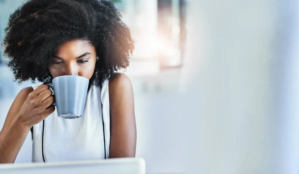 Kaffee bringt sie in Schwung. Schnappschuss einer attraktiven jungen Geschäftsfrau, die in ihrem Büro eine Tasse Kaffee trinkt. — Stockfoto