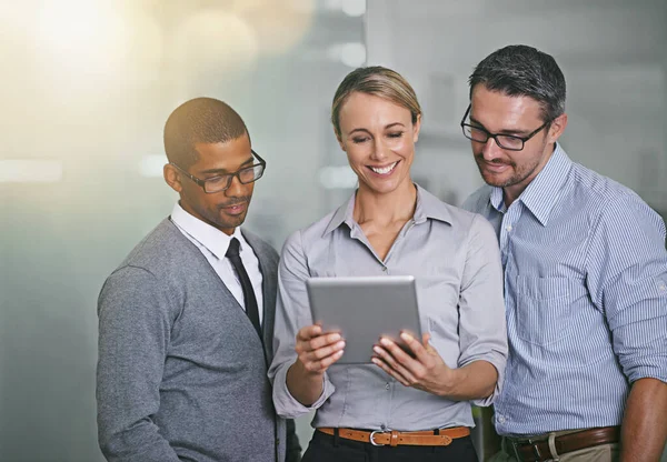 Секрет успеха бизнеса. Обрезанный снимок трех бизнесменов, работающих над цифровым планшетом. — стоковое фото