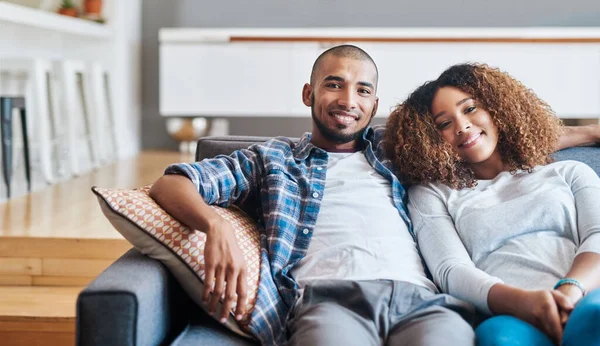 Passez le week-end avec celui que vous aimez. Portrait d'un jeune couple heureux se relaxant ensemble sur le canapé à la maison. — Photo