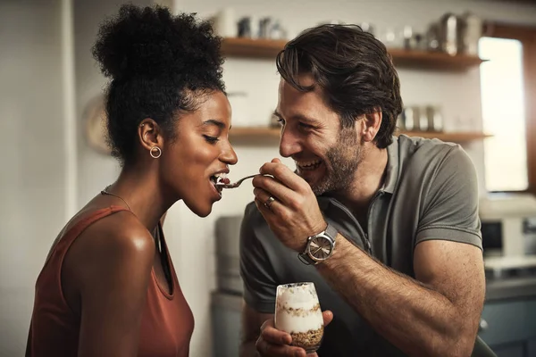 I know its your favourite. Cropped shot of an affectionate middle aged man feeding his wife dessert in their kitchen at home. — Stock Photo, Image