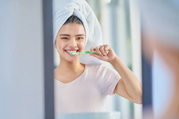 Mantendo-me branco-perolado. Retrato recortado de uma bela jovem escovando os dentes no banheiro em casa. — Fotografia de Stock