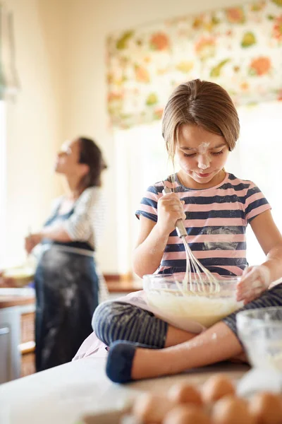 E 'disordinata, ma naturale. Girato di una bambina che aiuta sua madre a cuocere in cucina. — Foto Stock