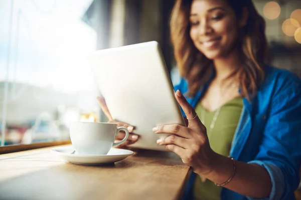 Caffè e wifi gratis, questo è il doppio del divertimento. Colpo ritagliato di una giovane donna attraente che utilizza un tablet digitale in un caffè. — Foto Stock
