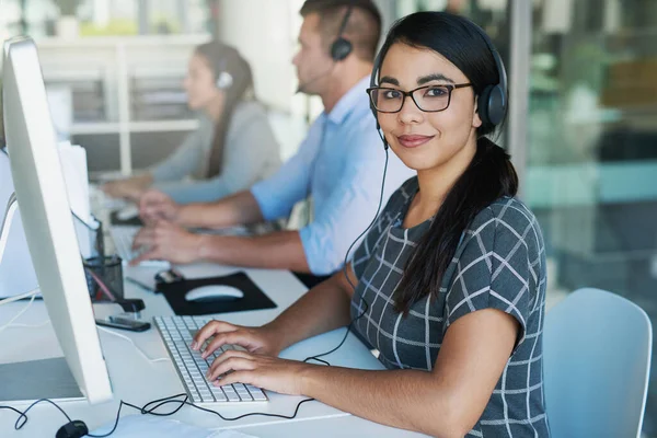 Ihr Anruf ist uns wichtig. Porträt einer glücklichen und selbstbewussten jungen Frau, die in einem Callcenter arbeitet. — Stockfoto