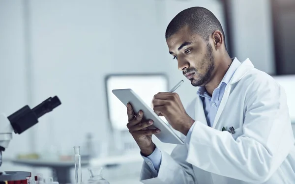 Forschung spielt eine große Rolle bei der Lösung von Problemen. Aufnahme eines Wissenschaftlers, der seine Erkenntnisse auf einem digitalen Tablet festhält. — Stockfoto