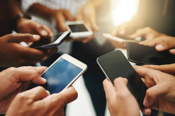 Wären alle miteinander verbunden. Nahaufnahme einer Gruppe unkenntlich gemachter Geschäftsleute, die synchron ihre Mobiltelefone benutzen. — Stockfoto