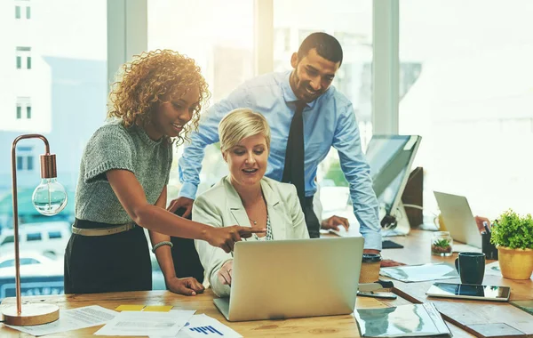 Faire des plans pour le rendre grand ensemble. Tournage d'un groupe d'hommes d'affaires travaillant ensemble sur un ordinateur portable dans un bureau. — Photo