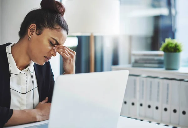 A luta é real. Tiro de uma jovem empresária olhando estressada enquanto trabalhava em sua mesa em um escritório moderno. — Fotografia de Stock