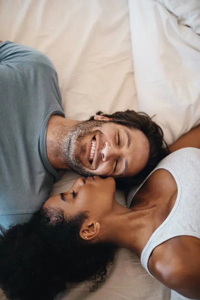 Tu eşti motivul fericirii mele. Cropped shot de un cuplu fericit tânăr culcat în pat împreună. — Fotografie, imagine de stoc