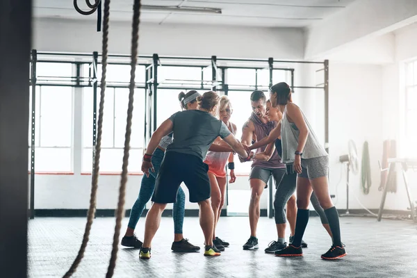 We zitten hier samen in. Opname van een fitnessgroep die traint in de sportschool. — Stockfoto