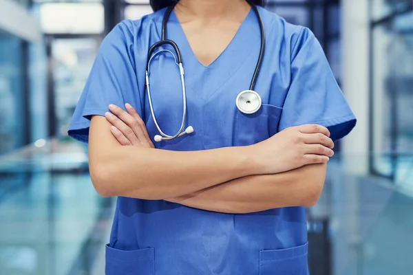 Η πρώτη γραμμή της υγειονομικής περίθαλψης. Προσωπογραφία νεαρής γυναίκας γιατρού που στέκεται με τα χέρια σταυρωμένα σε νοσοκομείο. — Φωτογραφία Αρχείου