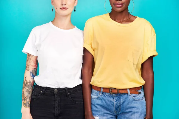 Leerzeichen für Ihr Branding. Ausgeschnittene Studioaufnahme von zwei jungen Frauen, die zusammen vor türkisfarbenem Hintergrund stehen. — Stockfoto