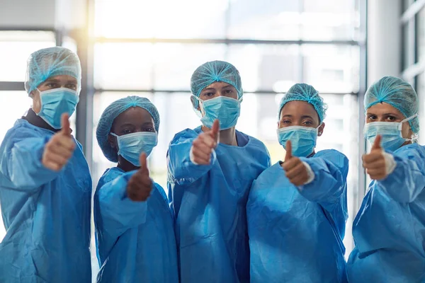L'intervento e 'stato un successo. Ritratto di un gruppo di medici che mostra i pollici in alto in un ospedale. — Foto Stock