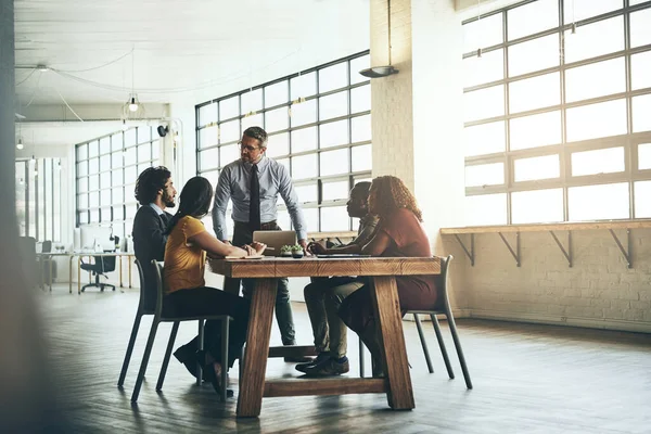 Collaborare per unire le loro abilità. Foto di un uomo d'affari ben vestito che presenta una nuova idea ai suoi colleghi in ufficio. — Foto Stock