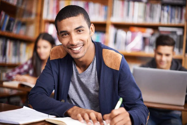 Hij is zo 'n ijverige leerling. Gesneden portret van een knappe jonge student die ijverig werkt in zijn klaslokaal. — Stockfoto