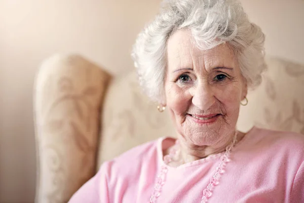 Rimpels moeten alleen maar aangeven waar de glimlach is geweest. Shot van een oudere vrouw ontspannen thuis. — Stockfoto