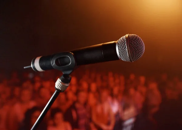 Sube al escenario.... Un micrófono de pie en un escenario con una multitud en el fondo. —  Fotos de Stock