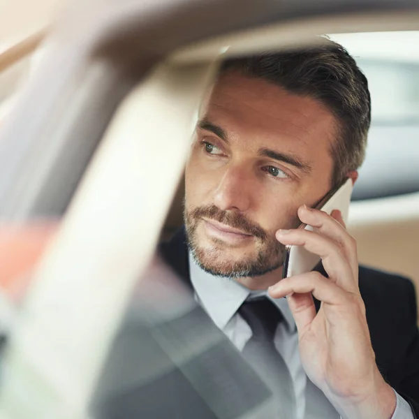 A tirar mais do seu trajecto com tecnologia sem fios. Tiro de um homem de negócios usando seu telefone enquanto viaja em um carro. — Fotografia de Stock