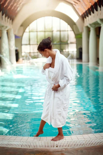 Sumérgete en un día de lujo. Foto de una atractiva joven a punto de darse un baño relajante en un spa. — Foto de Stock