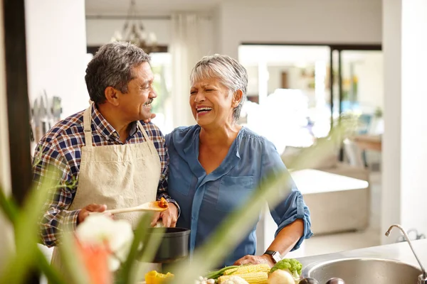 Sok szeretetet fektetnek az ételükbe. Egy boldog idős párról, akik egészséges vacsorát főznek otthon.. — Stock Fotó