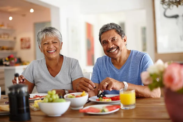 Zdrowy start do dnia. Strzał szczęśliwej pary seniorów, delektującej się wspólnym śniadaniem w domu. — Zdjęcie stockowe
