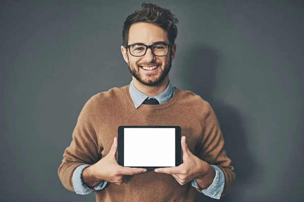 Talvez esteja na hora de colocar o seu negócio online. Retrato de estúdio de um jovem segurando um tablet digital com uma tela em branco contra um fundo cinza. — Fotografia de Stock