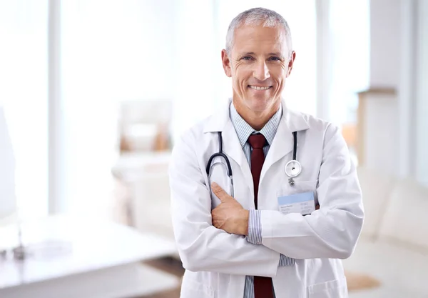 Tengo algunas buenas noticias. Retrato de un médico maduro sonriendo a la cámara. — Foto de Stock