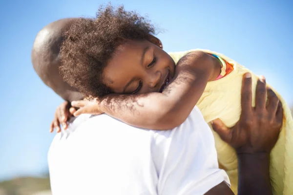 Jag älskar dig, pappa. En förtjusande afrikansk-amerikansk fallande dotter som sover på sina fäders axlar på stranden.. — Stockfoto