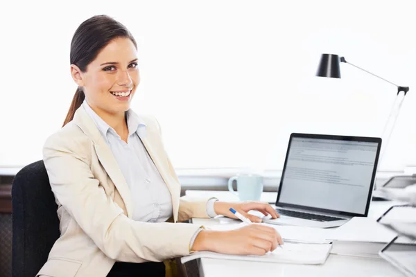 Totale tevredenheid over je werk. Portret van een jonge zakenvrouw zittend aan een bureau in een kantoor. — Stockfoto