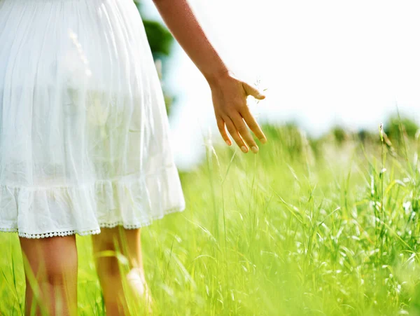 Дотик до природи. Обрізаний вид молодої жінки, що йде через зелене поле . — стокове фото