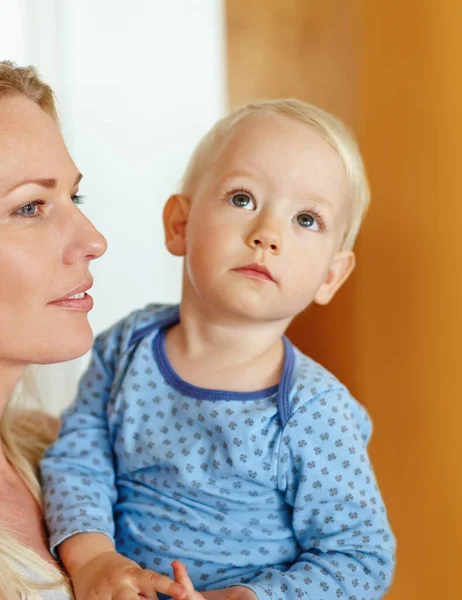 Hij heeft haar ogen. Een mooie jonge moeder die haar zoontje vasthoudt. — Stockfoto