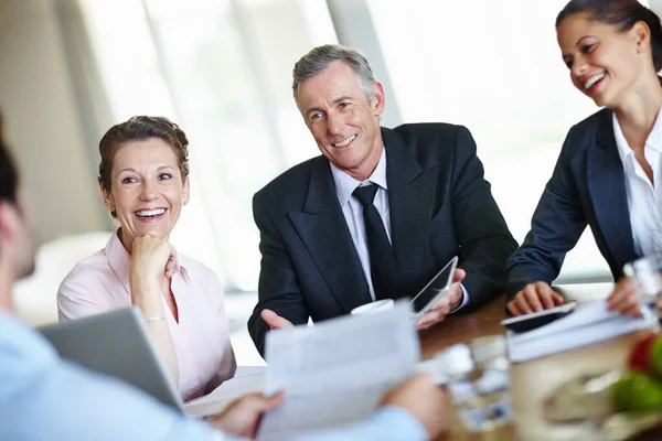 Genieten van een stimulerende zakelijke discussie. Een groep zakenmensen die een vergadering houden en zaken bespreken. Stockfoto