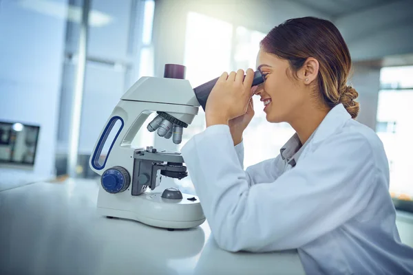 Wat een fascinerende vondst hebben we hier.... Foto van een jonge wetenschapper met behulp van een microscoop in een lab. — Stockfoto
