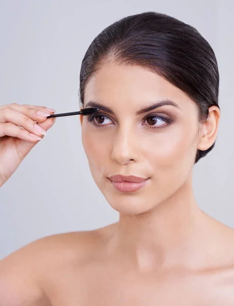 Dazu kommt ihre natürliche Schönheit. Aufnahme einer schönen jungen Frau, die Mascara auf ihre Wimpern aufträgt. — Stockfoto