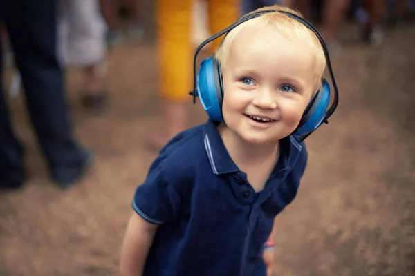 El mejor momento de su joven vida. Primer plano de un niño joven con auriculares de cancelación de ruido en un festival al aire libre. —  Fotos de Stock