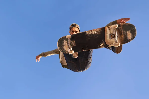 Heb je de vaardigheden van deze gezien? Een jonge man doet trucs op zijn skateboard in het skate park. — Stockfoto