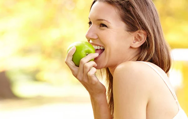 É mais do que apenas uma maçã.... Tiro de uma jovem mulher atraente no parque em um dia de outono. — Fotografia de Stock