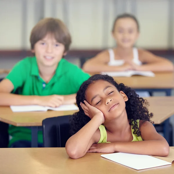 Le sue menti in un altro posto del tutto. Una bambina che sogna ad occhi aperti durante una lezione scolastica. — Foto Stock