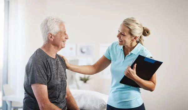 Te llevaré de vuelta a 100 en poco tiempo. Fotografía recortada de una fisioterapeuta femenina madura que trabaja con un paciente masculino mayor en su consultorio. — Foto de Stock