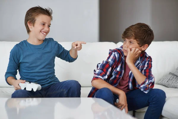 Haha, je hebt weer verloren. Schot van een jonge jongen lachen om zijn vriend na het verslaan van hem op een video game. — Stockfoto