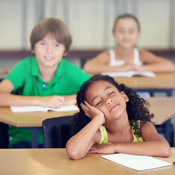 Her minds in another place entirely. A little girl daydreaming during a school lesson. — Stock Photo, Image