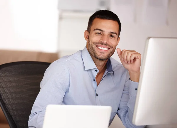 Si tu veux le meilleur, choisis-moi. Portrait d'un jeune homme souriant assis derrière un écran d'ordinateur. — Photo