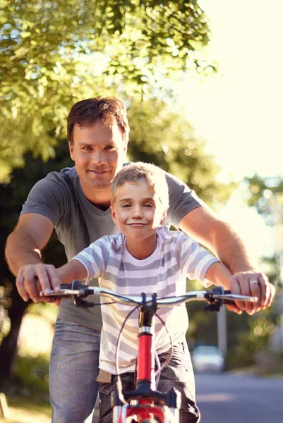 Meinem Jungen das Fahrradfahren beibringen. Aufnahme eines Vaters und seines Sohnes, die zusammen mit einem Fahrrad Zeit verbringen. — Stockfoto