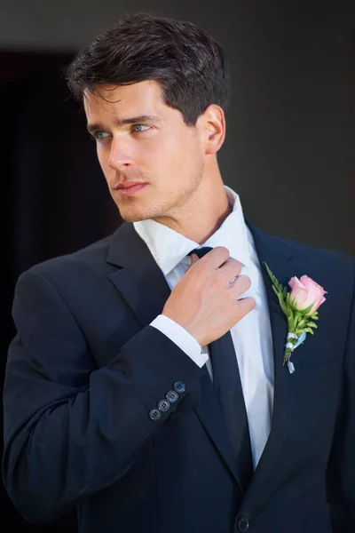 Se ve muy bien en su gran día. Un novio guapo con una rosa en su chaqueta aislada sobre un fondo negro. —  Fotos de Stock
